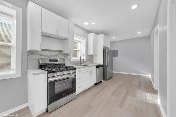 a kitchen with stainless steel appliances granite countertop a stove a sink and a refrigerator