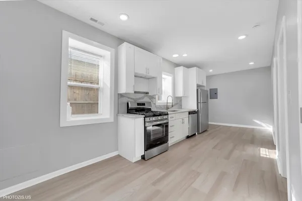 a kitchen with stainless steel appliances granite countertop a stove a sink and a refrigerator