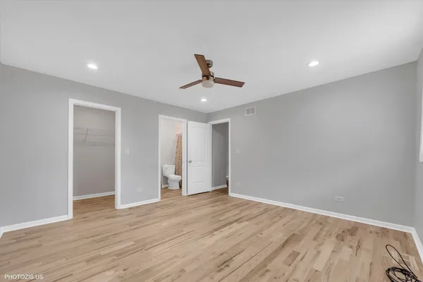 a view of a room with wooden floor and a ceiling fan