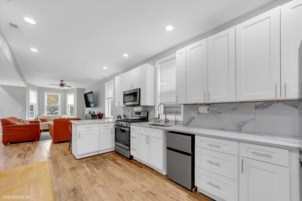 a kitchen with stainless steel appliances granite countertop a sink dishwasher stove refrigerator and cabinets
