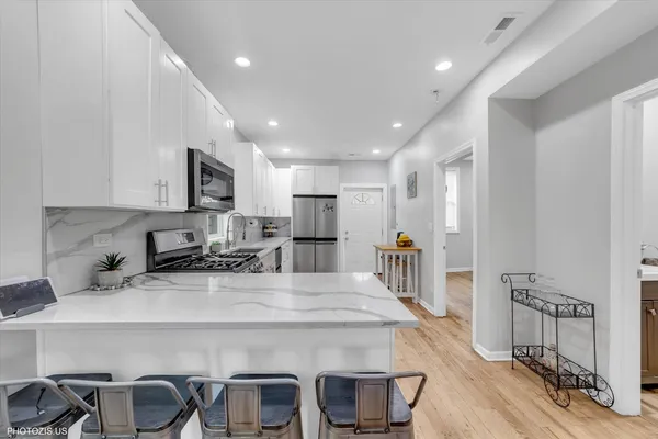 a kitchen with kitchen island a appliances dining table and chairs