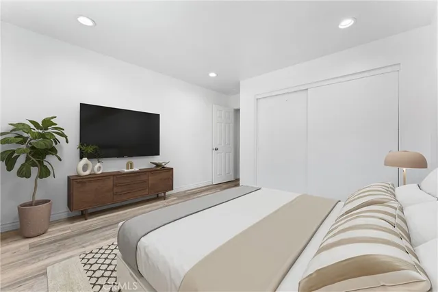 a bedroom with a bed and a flat screen tv