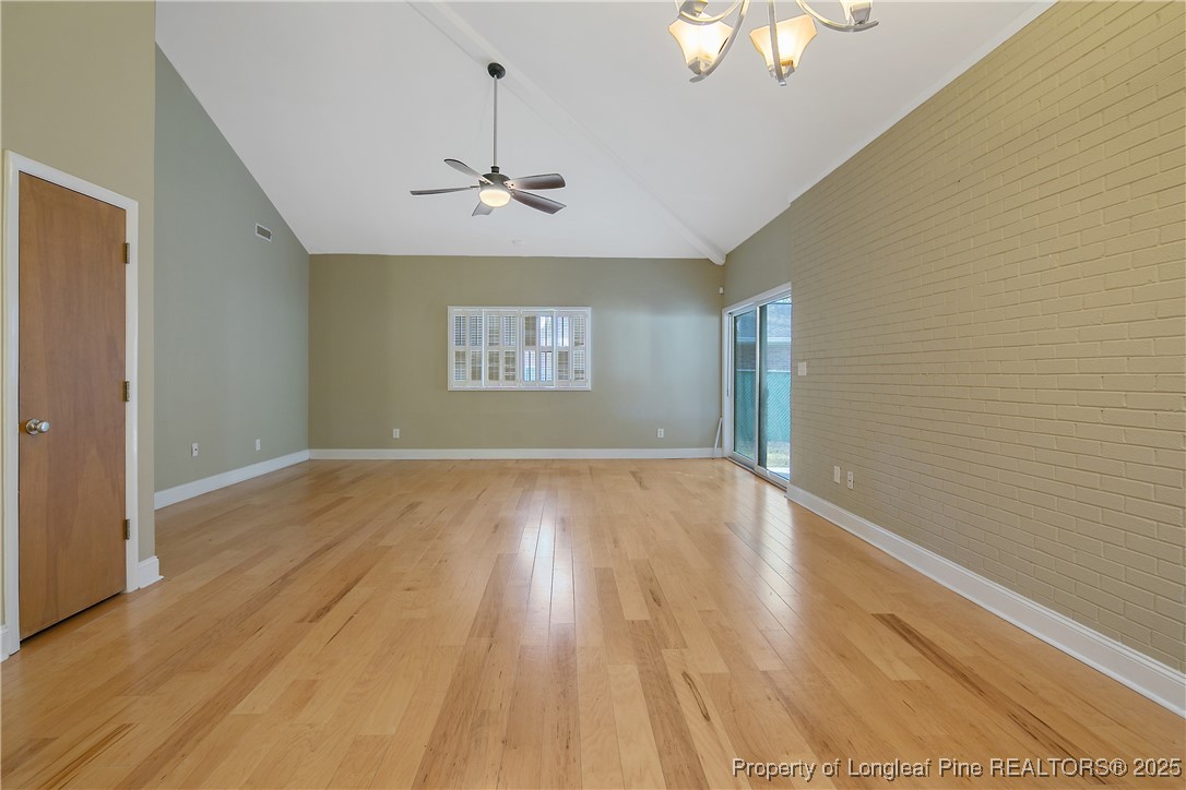 2118 Winterlochen Road Fayetteville, NC 28305 - Photo 13 of 50 an empty room with wooden floor chandelier fan and windows