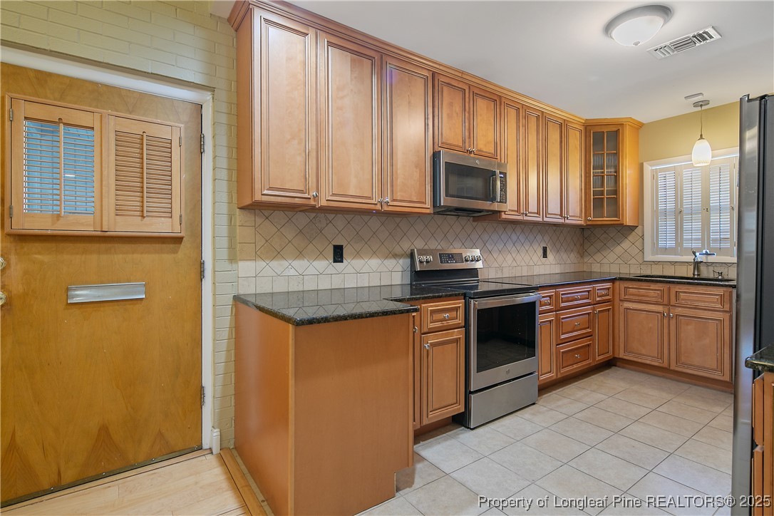 2118 Winterlochen Road Fayetteville, NC 28305 - Photo 14 of 50 a kitchen with stainless steel appliances granite countertop a stove a sink and a microwave
