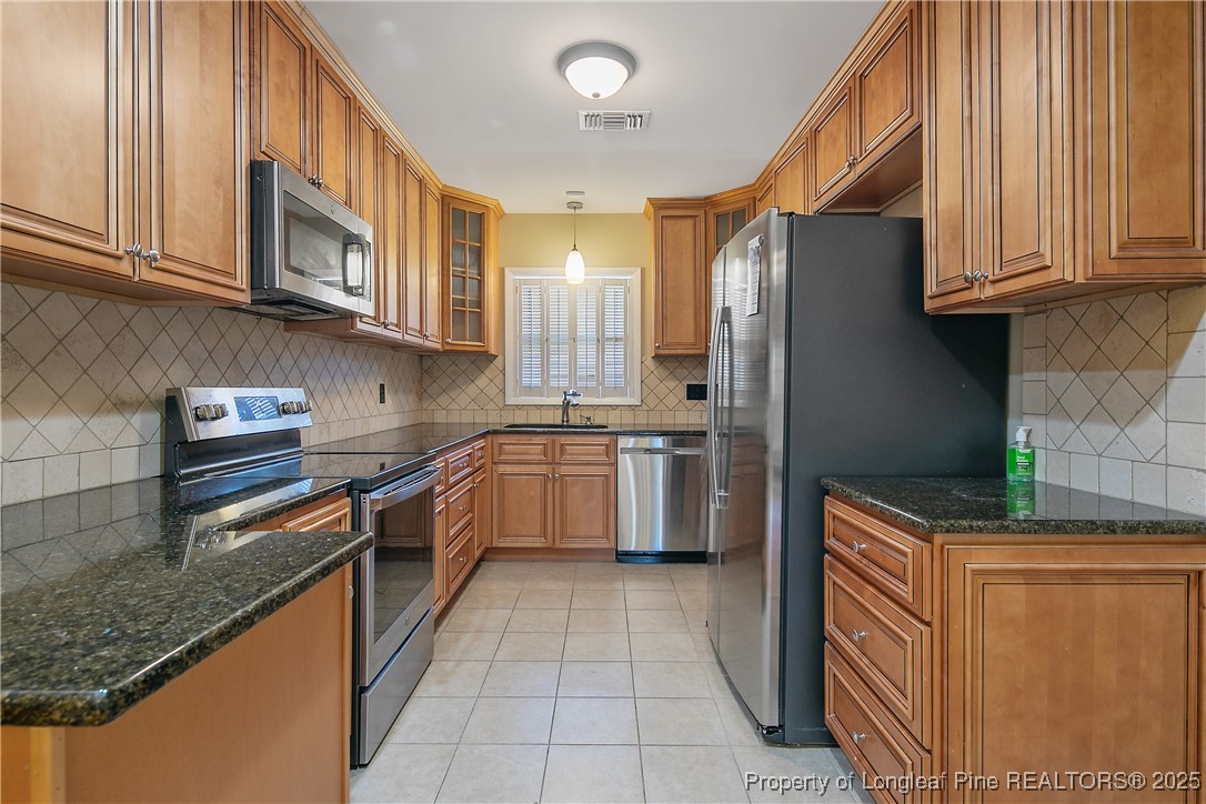 2118 Winterlochen Road Fayetteville, NC 28305 - Photo 15 of 50 a kitchen with stainless steel appliances granite countertop a stove a sink and a microwave
