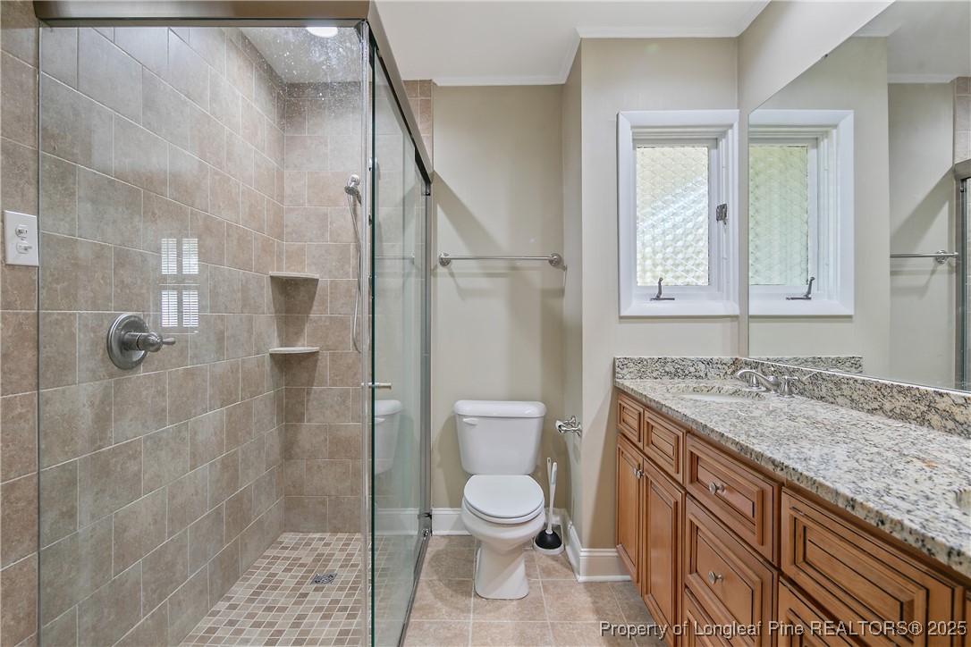 2118 Winterlochen Road Fayetteville, NC 28305 - Photo 31 of 50 a bathroom with a granite countertop toilet a sink and a shower