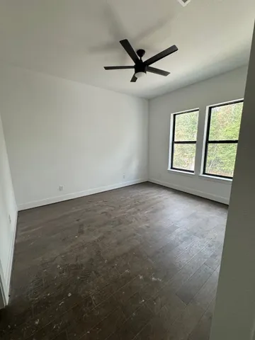 a view of a livingroom with a ceiling fan and window