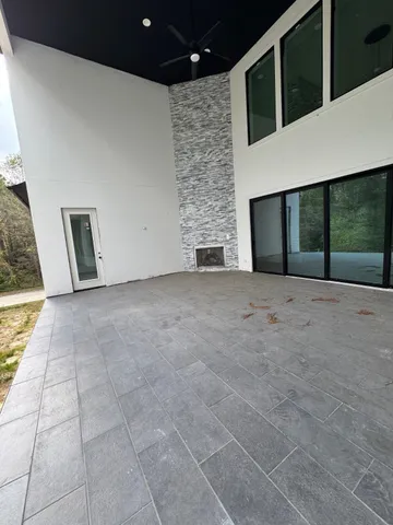 an empty room with windows and ceiling fan