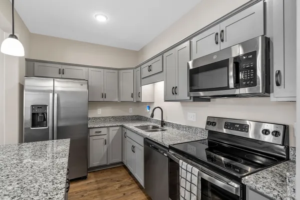a kitchen with stainless steel appliances granite countertop a stove microwave and refrigerator