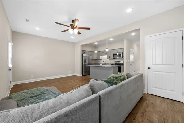 a living room with kitchen island furniture and a ceiling fan