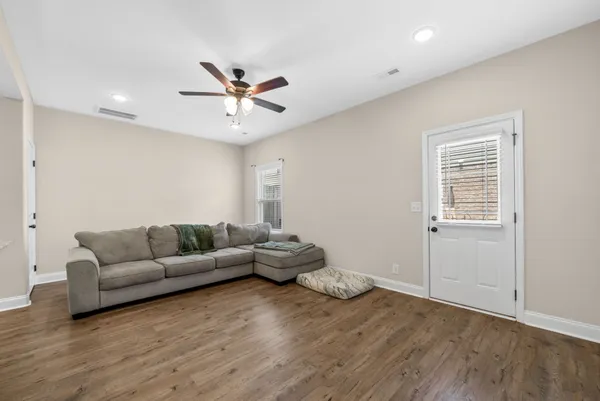 a living room with furniture and a wooden floor