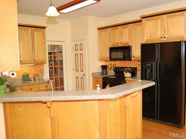 Bright sunny kitchen has smooth-topped stove, built-in microwave, dishwasher, pantry, convenient bar and lots of counter and cabinet space. Kitchen
