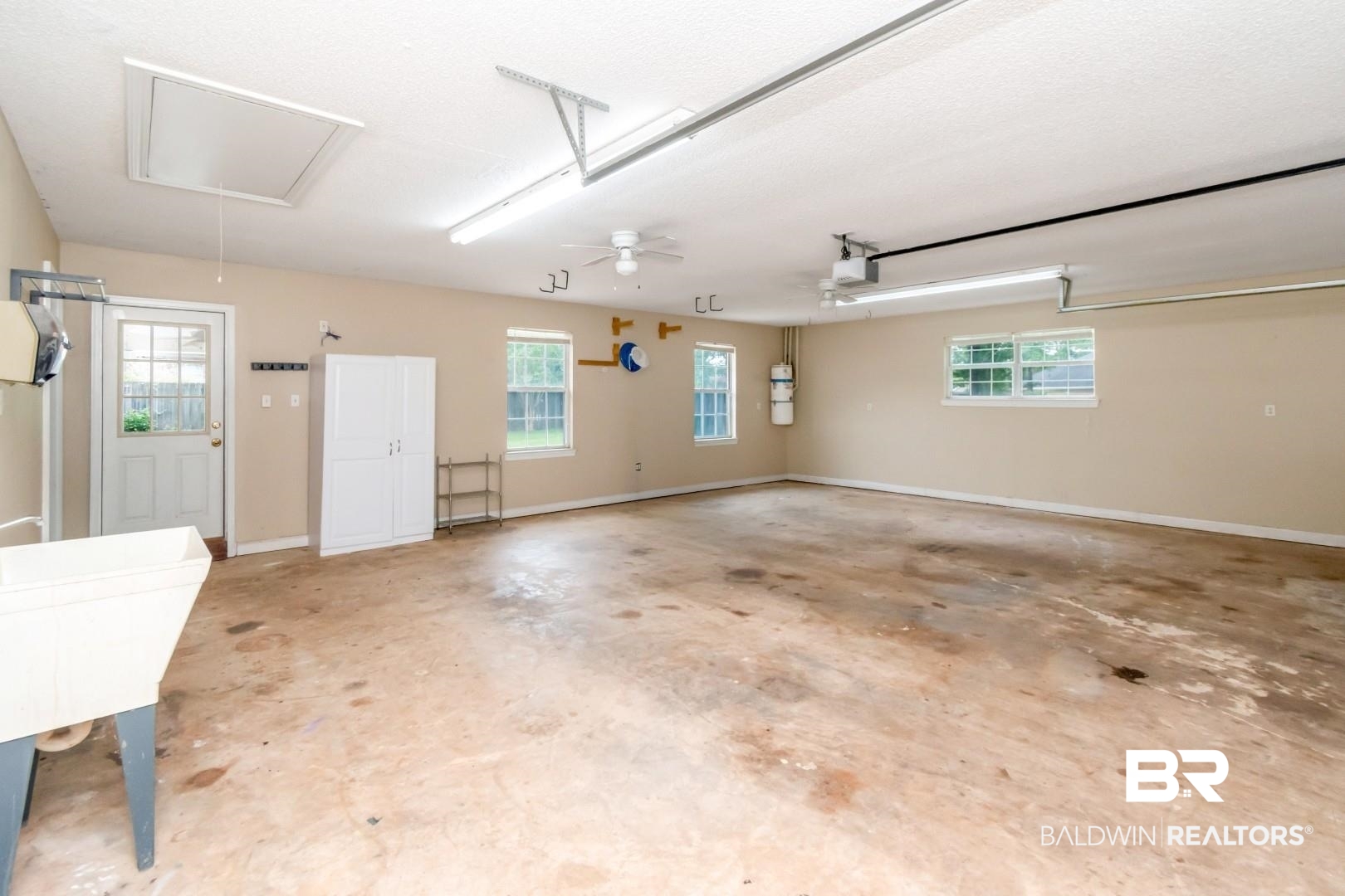 10691 Hunters Ridge Drive Mobile, AL 36695 - Photo 25 of 37 Spacious garage with multiple windows for natural light, an overhead access panel, and a utility sink