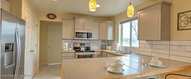 a kitchen with stainless steel appliances a sink a stove and a refrigerator