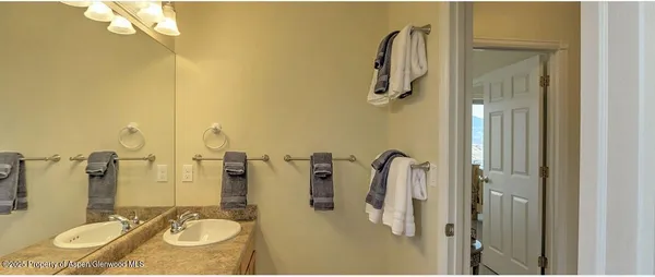 a bathroom with a sink vanity granite tub shower and a mirror