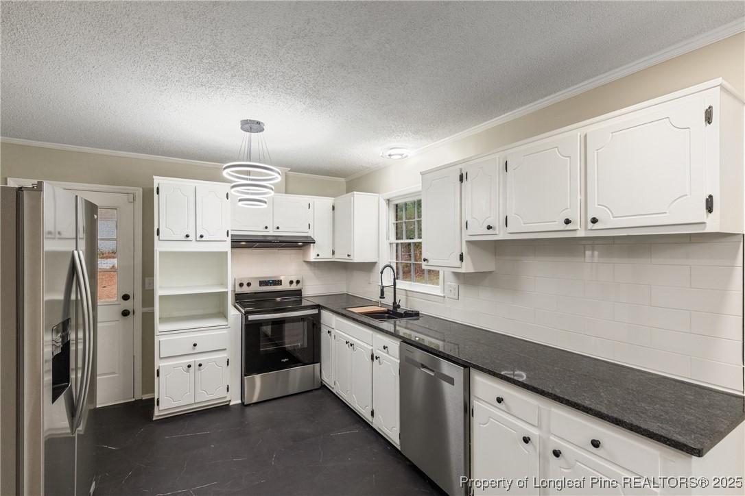 321 Summerhill Road Fayetteville, NC 28303 - Photo 8 of 26 a kitchen with stainless steel appliances white cabinets and a refrigerator
