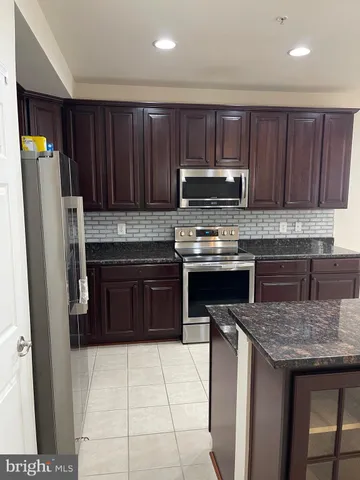a kitchen with granite countertop wood cabinets and stainless steel appliances