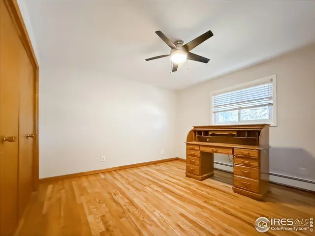 a view of a livingroom with wooden floor and a ceiling fan