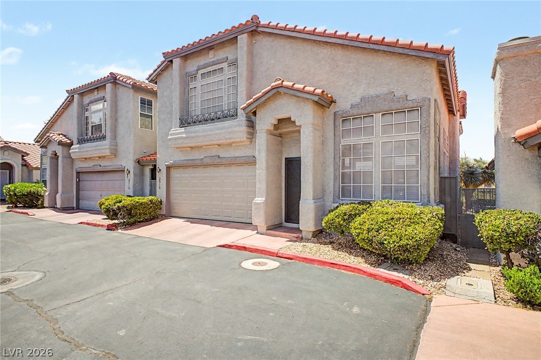 2316 Ramsgate Drive Henderson, NV 89074 - Photo 3 of 28 A classic stucco exterior, complete with an attached garage and terracotta roof tiles, greets visitors.