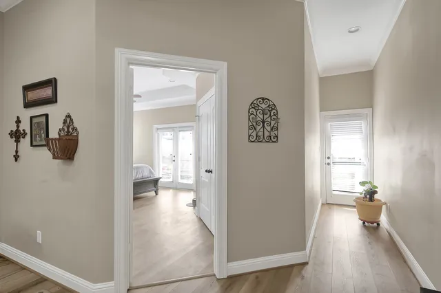 a view of a hallway view with wooden floor and a living room