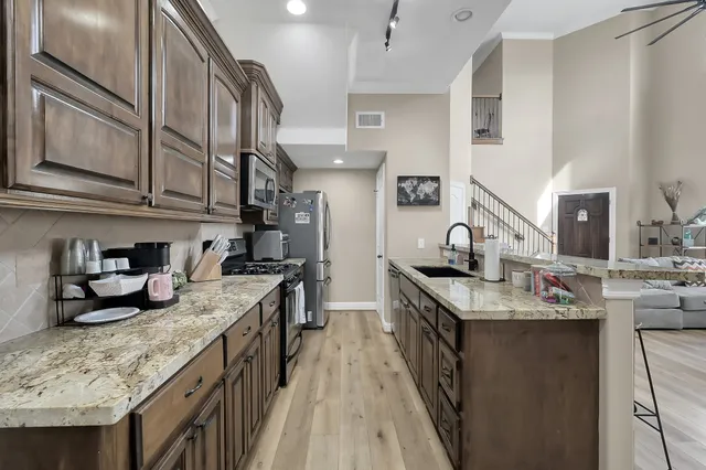 a kitchen with kitchen island granite countertop lots of counter top space and stainless steel appliances