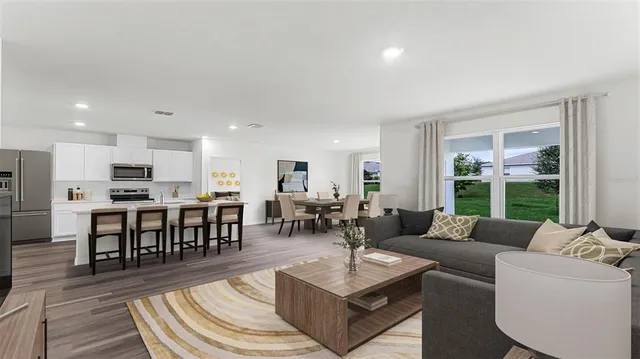 a living room with furniture wooden floor and a view of kitchen