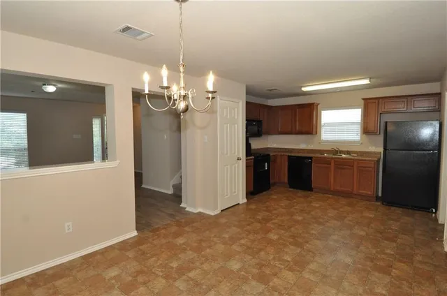 a view of a kitchen with a sink and refrigerator