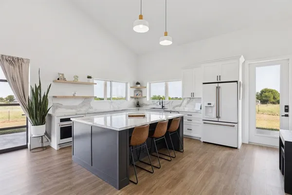a kitchen with white cabinets and wooden floor