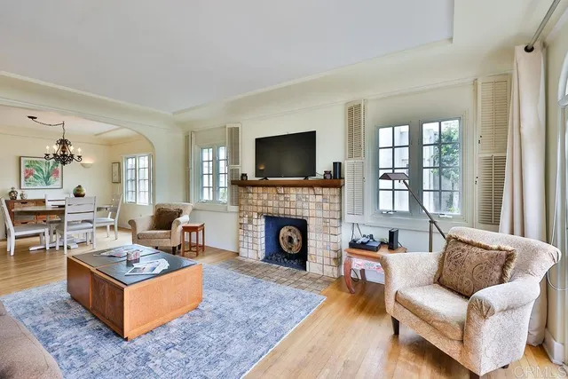 a living room with furniture fireplace and a large window