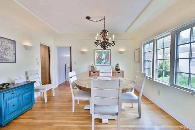 a view of a dining room with furniture a chandelier and wooden floor