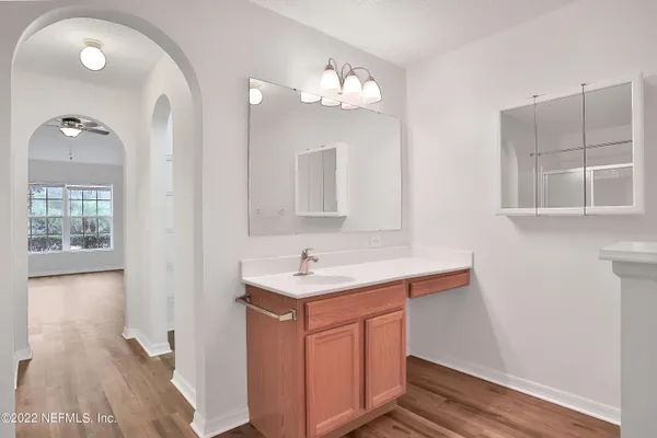 a bathroom with a sink a light fixture and a mirror
