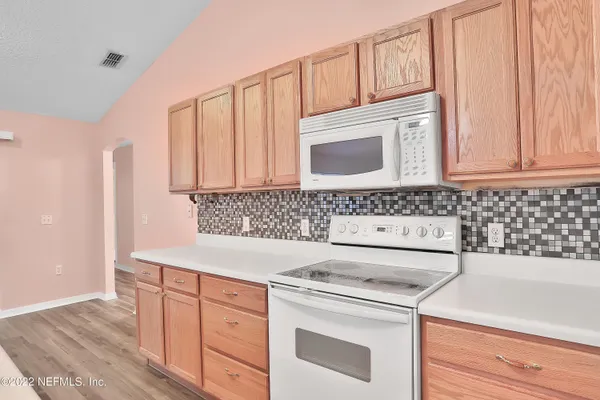 a kitchen with granite countertop white cabinets and white appliances