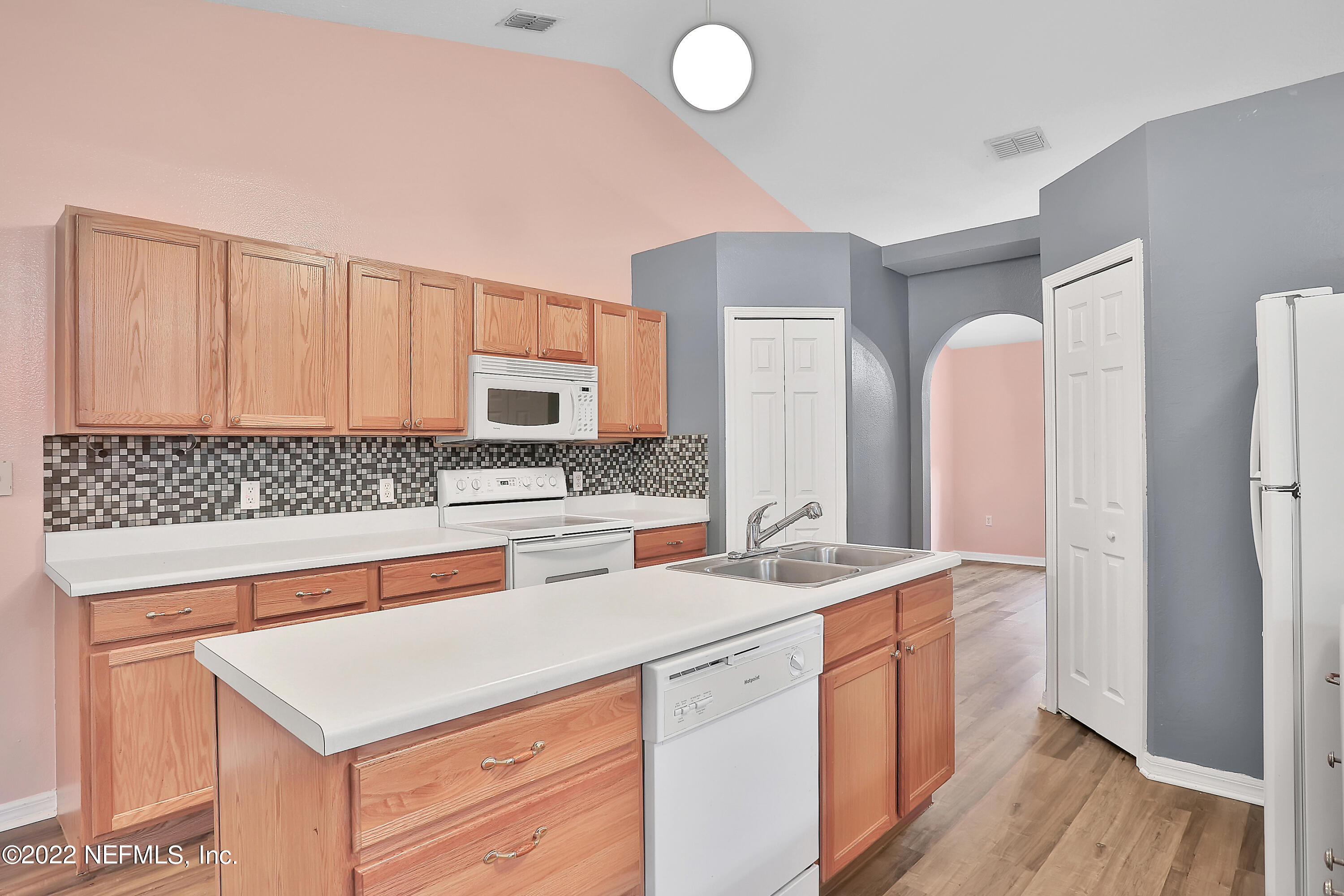 11 Wheatfield Drive Palm Coast, FL 32164 - Photo 19 of 36 a kitchen with stainless steel appliances granite countertop a sink and a stove with wooden floor