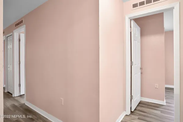 a view of a hallway with wooden floor