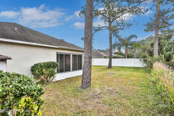 a view of a house with backyard and a tree