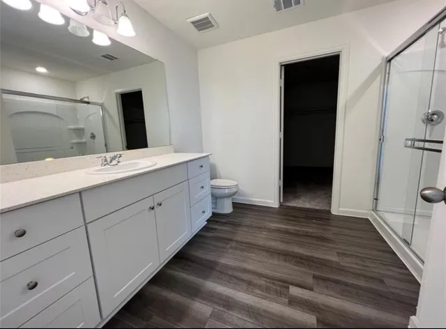 a spacious bathroom with a double vanity sink a large mirror and shower