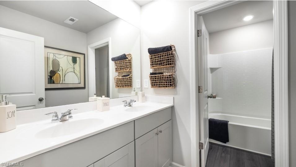 12240 Dakota Ridge Place North Fort Myers, FL 33917 - Photo 15 of 32 a bathroom with a double vanity sink a tub and a mirror