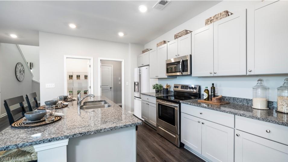 12240 Dakota Ridge Place North Fort Myers, FL 33917 - Photo 8 of 32 a kitchen with stainless steel appliances granite countertop a sink a stove and a refrigerator