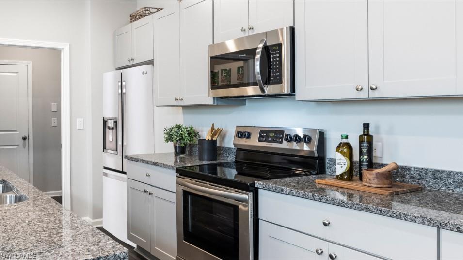 12240 Dakota Ridge Place North Fort Myers, FL 33917 - Photo 10 of 32 a kitchen with stainless steel appliances granite countertop white cabinets granite counter tops and a wooden floors