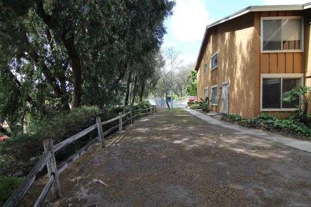 a view of a house with backyard and trees