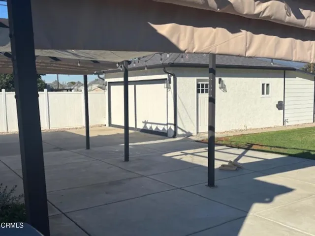 a view of a porch with a table and chairs under an umbrella