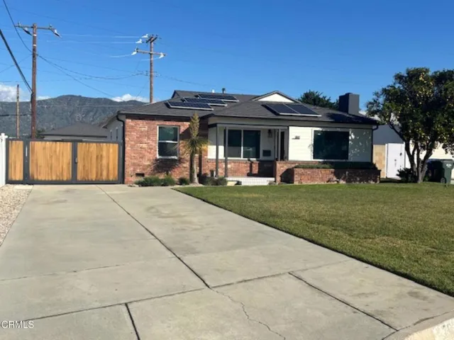 a front view of a house with a yard and potted plants