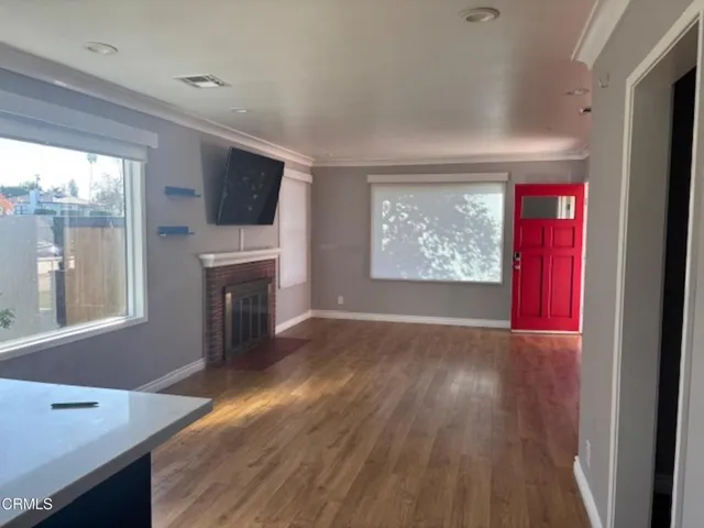 a view of an empty room with a window and fireplace