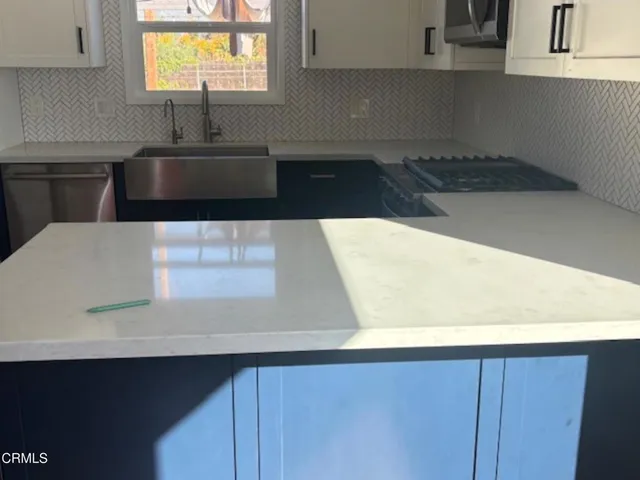 a kitchen with a sink and a stove top oven