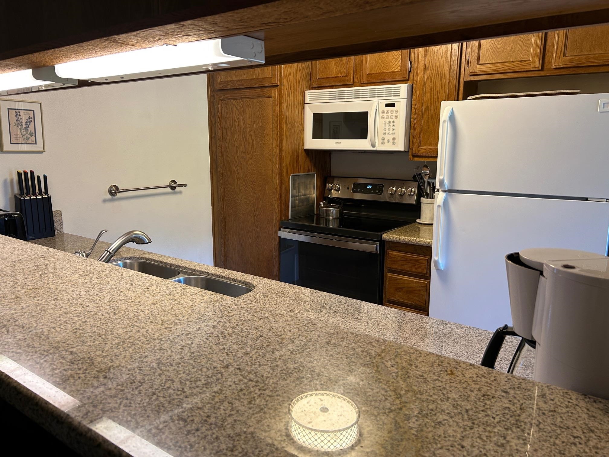266 Snowcreek Road, Unit 266 Mammoth Lakes, CA 93546 - Photo 15 of 27 a kitchen with a refrigerator and a stove top oven