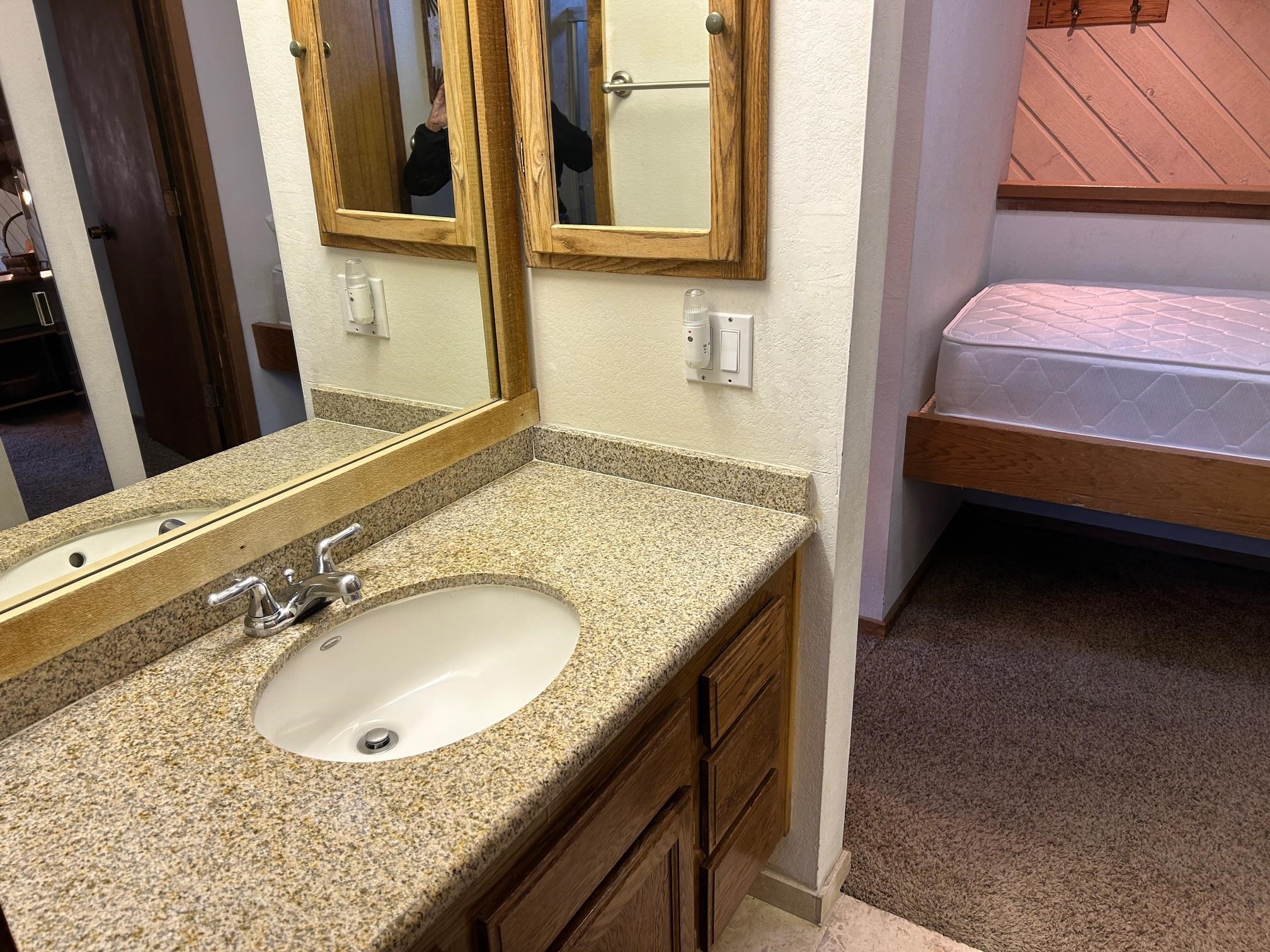 266 Snowcreek Road, Unit 266 Mammoth Lakes, CA 93546 - Photo 22 of 27 a bathroom with a granite countertop sink and a mirror
