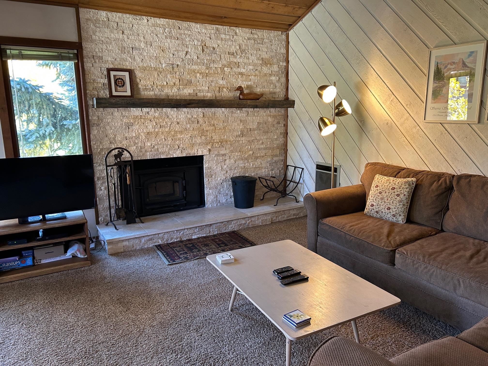 266 Snowcreek Road, Unit 266 Mammoth Lakes, CA 93546 - Photo 6 of 27 a living room with furniture a flat screen tv and a fireplace