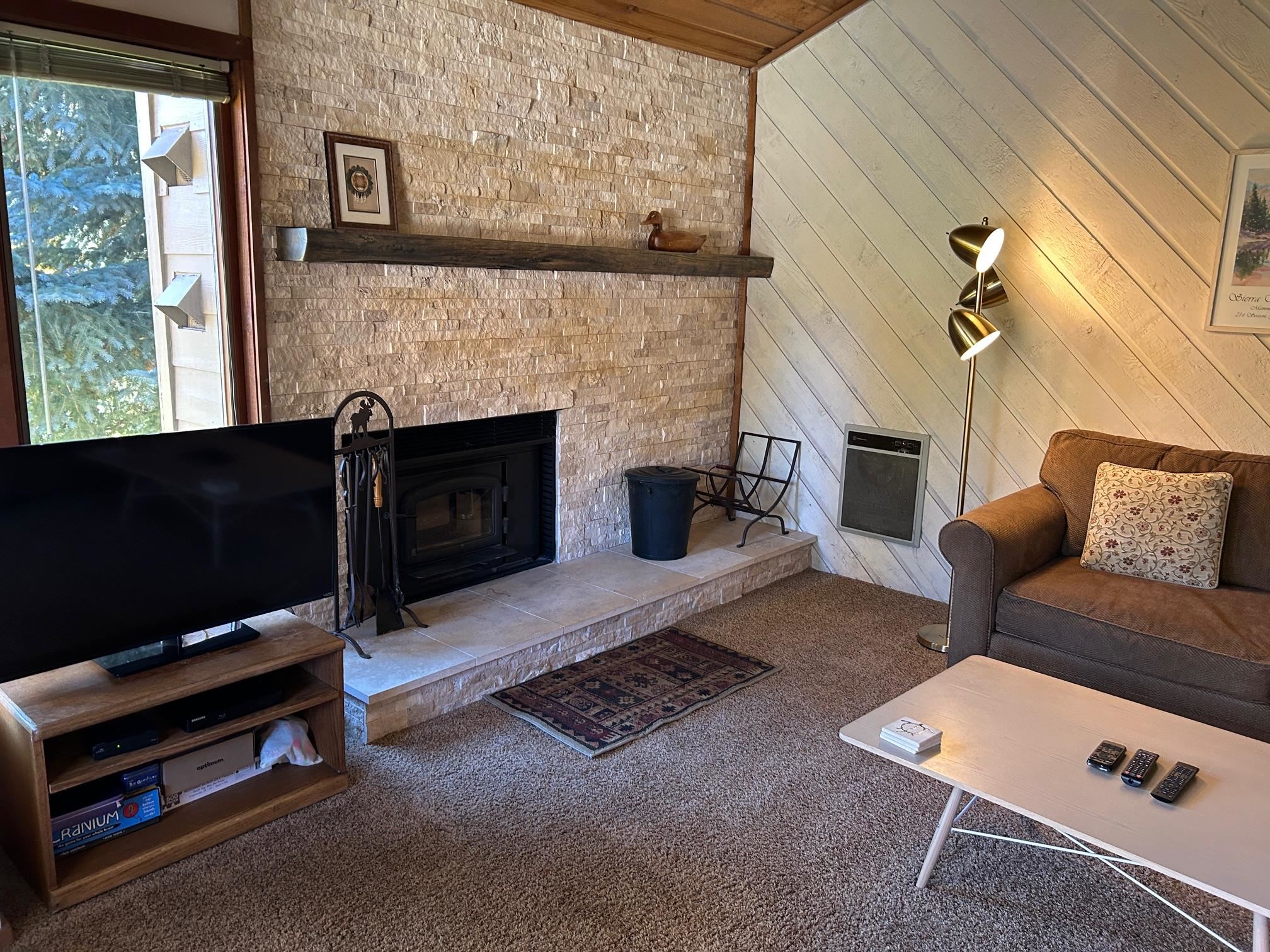 266 Snowcreek Road, Unit 266 Mammoth Lakes, CA 93546 - Photo 7 of 27 a living room with furniture a flat screen tv and a fireplace