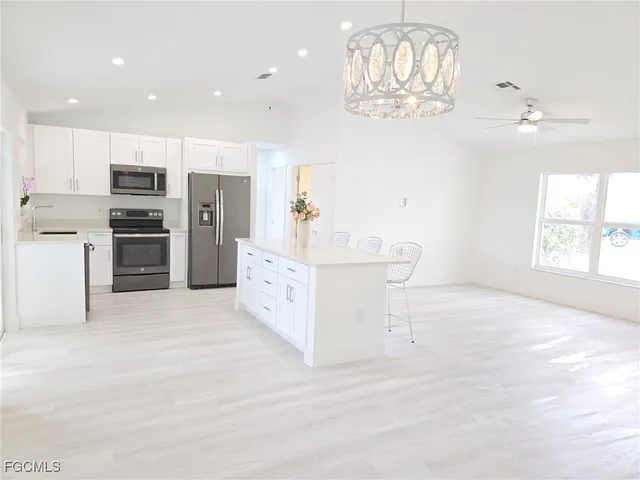 a spacious bedroom with a bed and a chandelier
