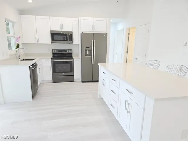 a kitchen with stainless steel appliances a refrigerator sink and cabinets